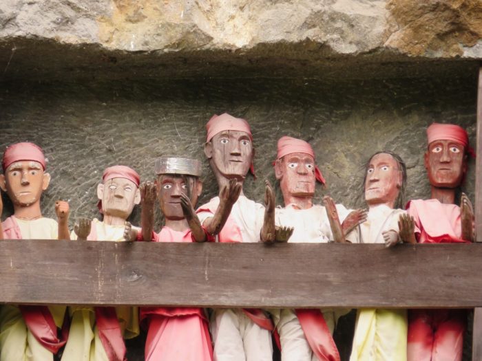 7 houten Tau Tau poppen in rotswand