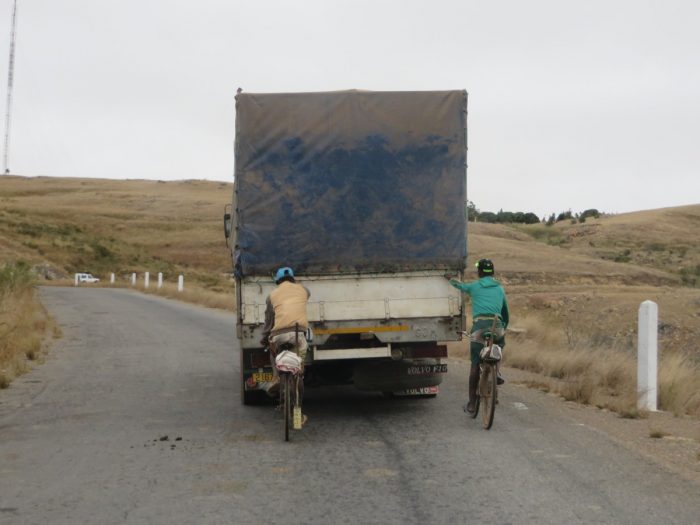 twee fietsers hangen achter vrachtwagen